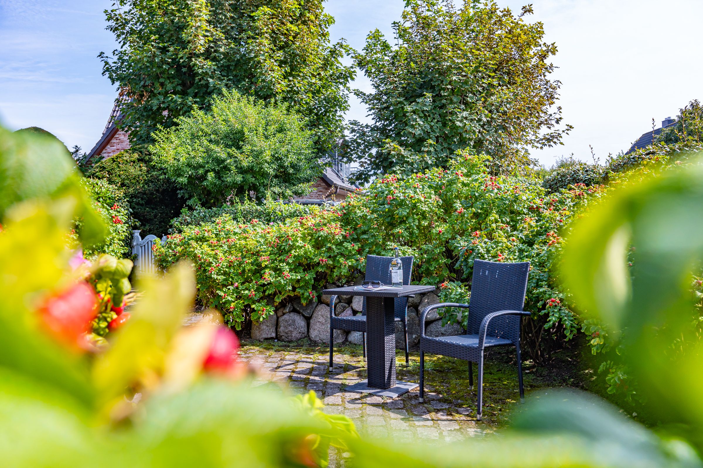 Büsche auf einem Wall, Tisch mit zwei Stühlen